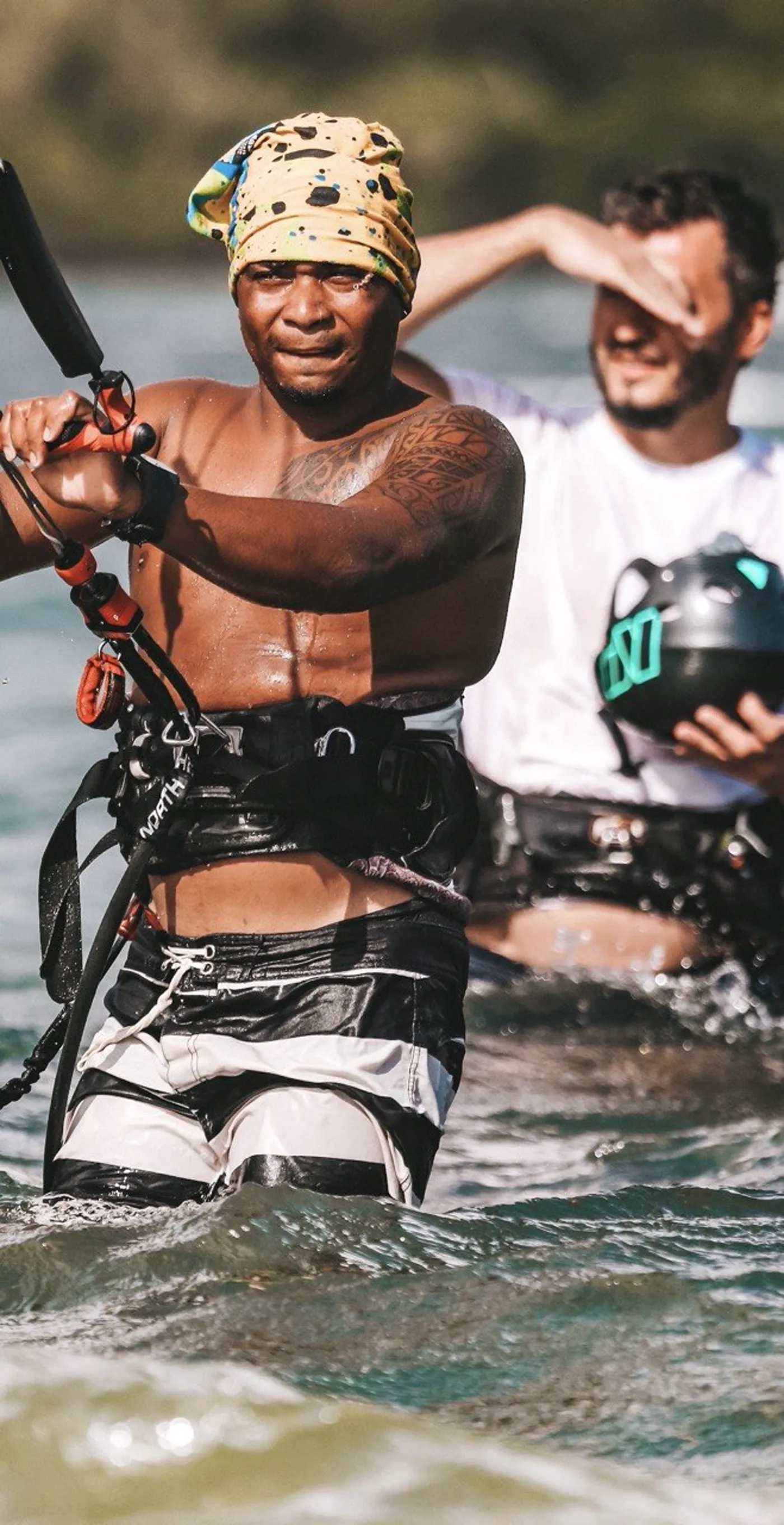 Student holding a control bar and wearing a harness during a kitesurfing lesson